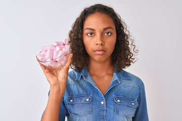 Canvas Print - Young brazilian woman holding bowl with marshmallows over isolated white background with a confident expression on smart face thinking serious