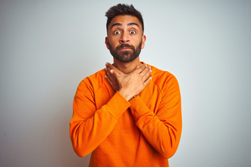 Sticker - Young indian man wearing orange sweater over isolated white background shouting and suffocate because painful strangle. Health problem. Asphyxiate and suicide concept.