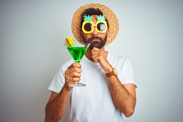 Wall Mural - Indian man wearing summer funny look drinking cocktail over isolated white background serious face thinking about question, very confused idea