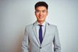 © Krakenimages.com - Asian chinese businessman wearing grey jacket and tie standing over isolated white background with a happy and cool smile on face. Lucky person.