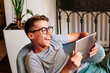 © lithiumphoto - Happy teenager boy using tablet sitting in the chair indoor