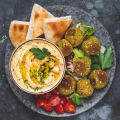 Wall Mural - Hummus with falafel and pita bread on plate. Arabic cuisine appetizer. Top view, square composition