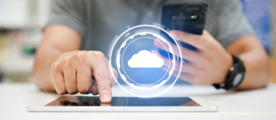 Wall Mural - close up businessman hand touchscreen on digital tablet and smartphone to transfer or synch data upload and download from cloud computing service with virtual interface for technology business concept