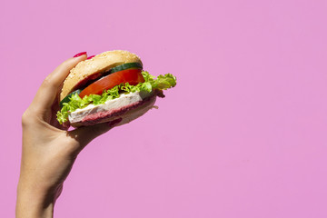 Wall Mural - Juicy burger on pink background with copy space