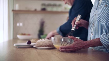 Wall Mural - Midsection of senior grandparents with small graddaugther indoors, cooking.