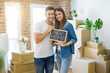 © Krakenimages.com - Beautiful young couple moving to a new house, smiling very happy holding blackboard with new home text