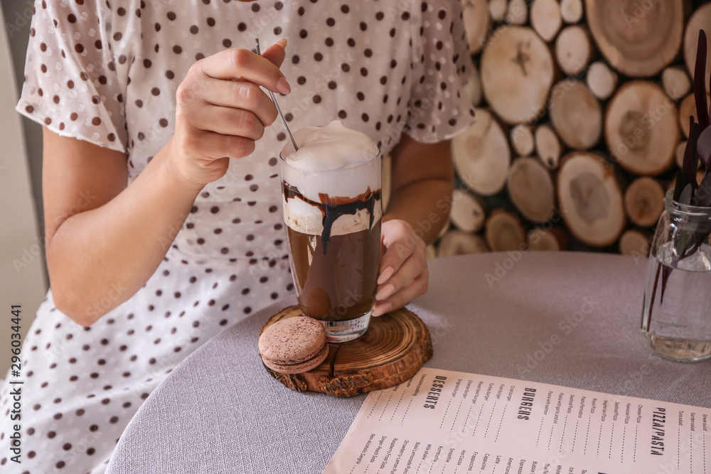 Woman drinking tasty frappe coffee in cafe