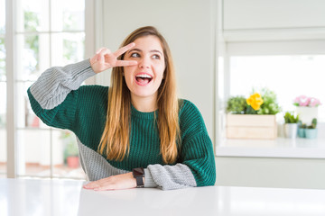 Poster - Young beautiful plus size woman wearing casual striped sweater Doing peace symbol with fingers over face, smiling cheerful showing victory