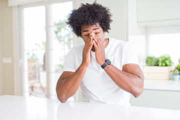 Poster - Young african american man wearing casual white t-shirt sitting at home rubbing eyes for fatigue and headache, sleepy and tired expression. Vision problem