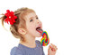 Girl licks candy on a stick. Isolated on a white background.