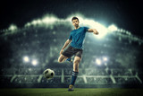 Fototapeta Sport - Soccer player in action on night stadium background
