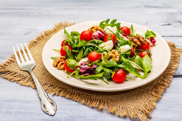 Fresh salad with arugula, radicchio, tomato cherry, baby mozzarella, walnuts