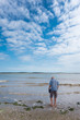 © david - Un homme marchant dans la mer. Pêcher les coquillages. Ramasser les coquillages sur la plage. Touriste à la mer. Vacances à Oléron. Un touriste sur la plage, le ciel bleu, la mer, un nuage.