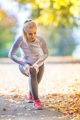 Female sporty young woman doing stretching or warming the body and preparing to jogging