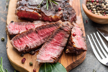 Wall Mural - Medium rare Ribeye steak with herbs and a piece of butter on the wooden tray.