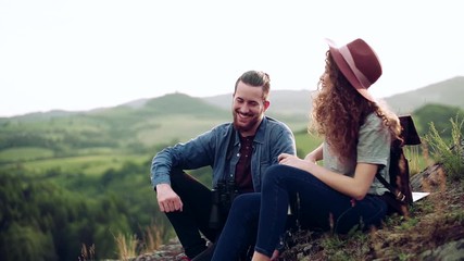 Wall Mural - young tourist couple travellers with hiking in nature, resting. slow motion.