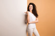 © deagreez - Photo of amazing lady indicating finger on empty discount banner standing near big white placard wear white casual clothes isolated beige pastel color background