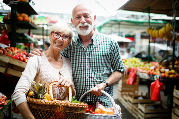 Wall Mural - Mature shopping couple with basket on the market. Healthy diet.