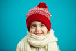 © Ilshat - portrait of beautiful little girl in red winter hat on blue background