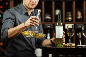 Wall Mural - Sommelier decants wine to decanter in cellar