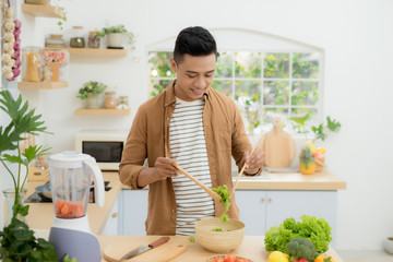 Young man preparing healthy vegetable salad