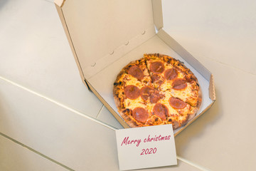 Wall Mural - Open box of pizza and card with text merry christmas 2020 on home doorstep on front porch. Delivery. Concept