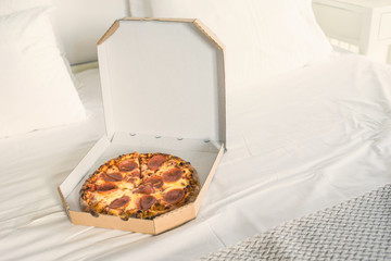 Wall Mural - Open box of pizza on the big bed. Concept