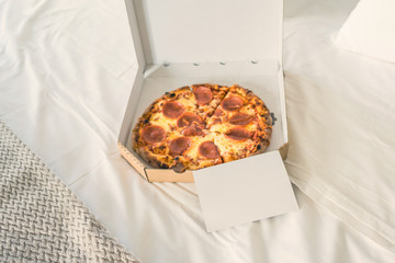 Wall Mural - Open box of pizza on the big bed with empty card for text. Concept