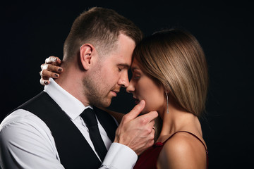 young romantic couple with closed eyes enjoying spending time together. close up portrait, isolated black background, studio shot. tenderness, feeling and emotion, support