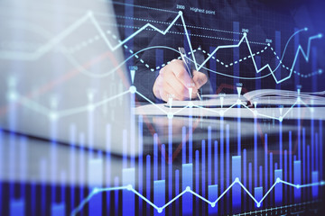 Double exposure of businessman with laptop and stock market forex chart.