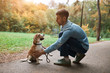 young handsome man teaching his dog to stand on two legs, paws, education, fulllength side view photo