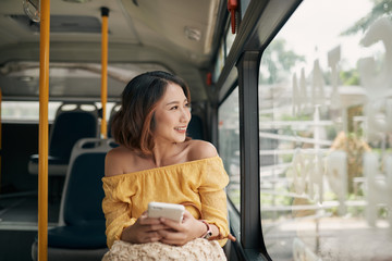 Wall Mural - Asian woman looking view outside the bus window.