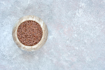 Wall Mural - Psyllium Husk seeds , fiber source , in marble bowl on light stone background. Top view with copy space