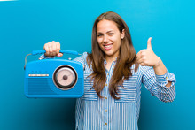 Young Woman With A Vintage Radio Against Blue Background