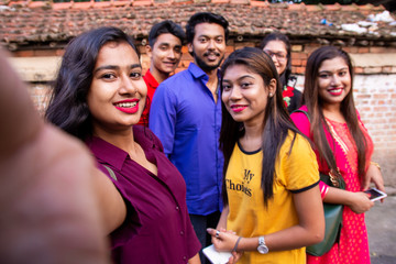 Best friends multiracial people taking selfie outdoor - Happy friendship concept with young students having fun together