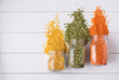 Three jar with yellow, orange and green  lentil scatter on white wooden  table. Image is top view and copy space