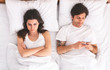 © Prostock-studio - Addicted man playing video game on cellphone in bed