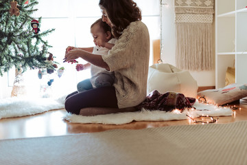 Wall Mural - mother and baby playing around the christmas tree