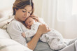 Leinwandbild Motiv Loving mom carying of her newborn baby at home