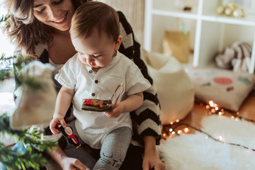 Mother and baby playing around the Christmas Tree