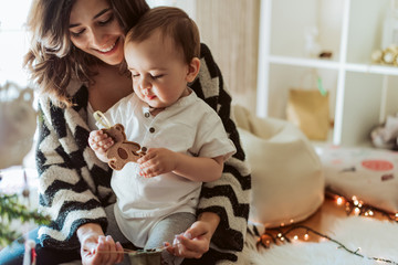 Wall Mural - Mother and baby playing around the Christmas Tree