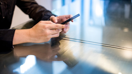 Mobile app for internet of things. Big data technology and cloud computing. Businessman hand texting message at bar counter in the cafe. Using smartphone for online shopping and internet banking.