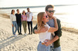 © Syda Productions - friendship, leisure and people concept - happy couple and group of friends on beach in summer