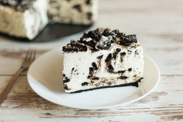 Unbaked creamy cheesecake with chocolate cookies and cream biscuits.