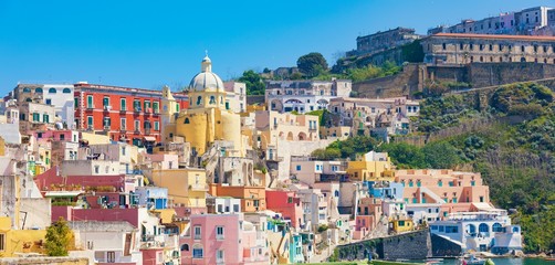 Wall Mural - Colorful vibrant houses on Marina Corricella in sunny day in Procida Island, Italy.