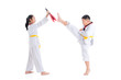 © gamelover - Two young asian children having taekwondo training ,one boy kicking while other one girl holding kick target over white background.