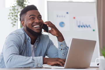 Wall Mural - Happy african american employee received good news on phone