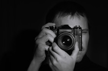 Black And White Portrait Of A Photographer With An Old Camera In His Hands On A Dark Background.horizontal Frame