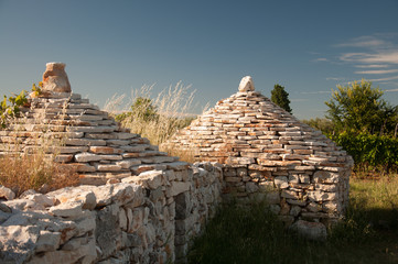 Close up of two traditional istrian huts - Kazun. With blue sky in background.