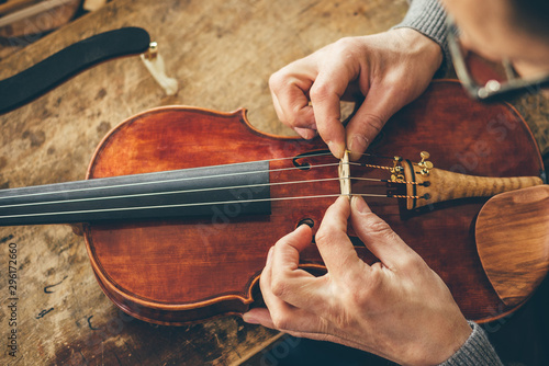Fotomural Luthier repair violin in his workshop